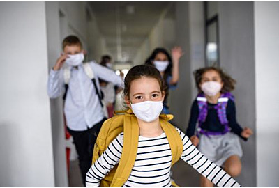 Gruppe fröhlicher Kinder, die nach Covid-19 Quarantäne und Schließung von der Schule nach Hause gehen.